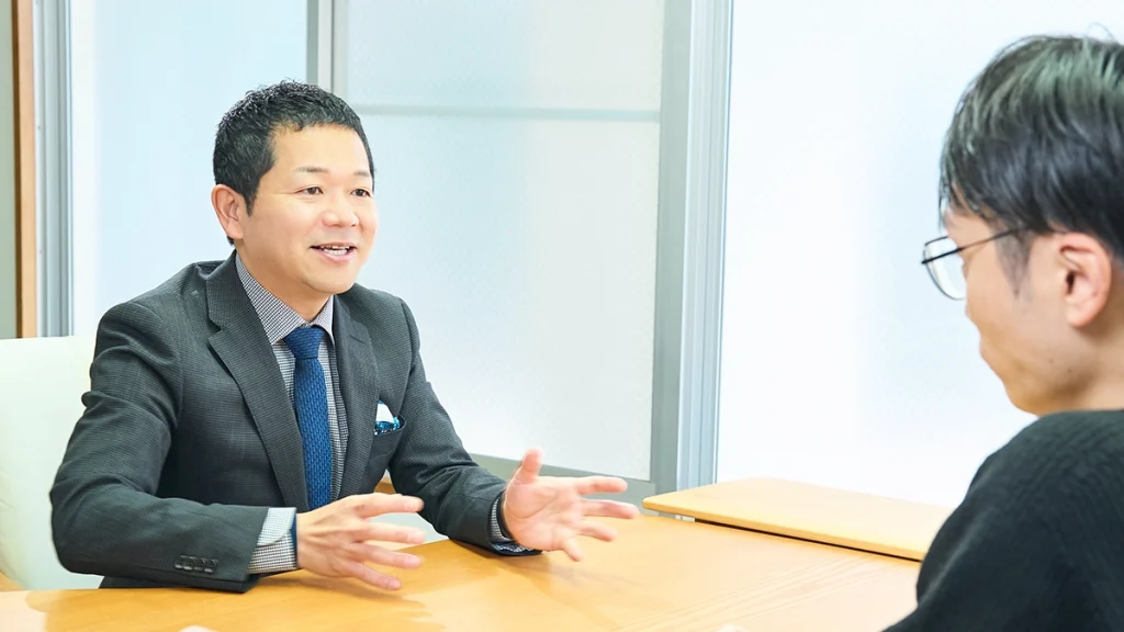 男性スタッフがお客様にたいして笑顔で説明をしている